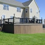 deck with stone columns and perimeter lighting