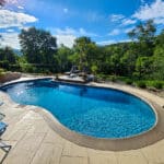 concrete pool and patio with ripples on the water