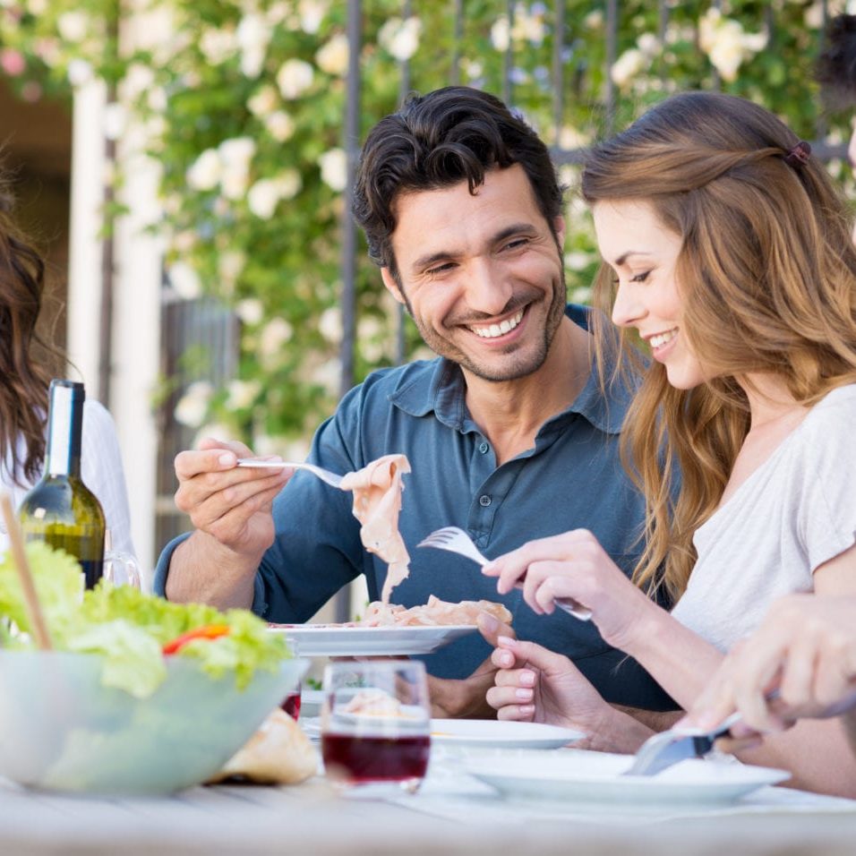 Group Of Happy Young Friends Having Dinner At Patio