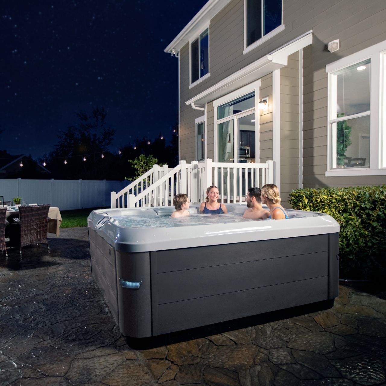 people enjoying an outdoor hot tub at night